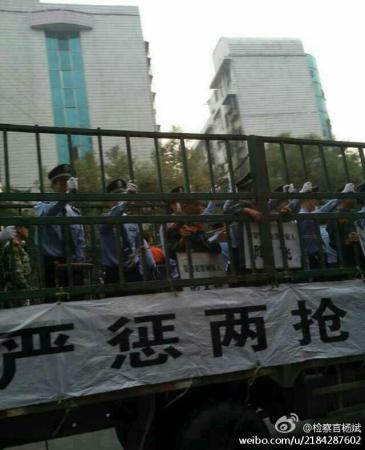 Suspects are standing behind iron bars on moving trucks. [Photo: Sina Weibo]
