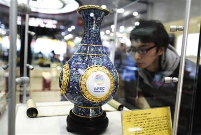 A visitor is wathcing a cloisonn�� vase, copies of which were sent by President Xi to visting APEC economic leaders as gifts. (Photo: Beijing News)
