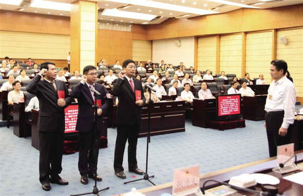 Three newly appointed officials take a solemn oath to Chinas Constitution on November 26, 2014. [Photo: Hainan Daily/ Li Chao]