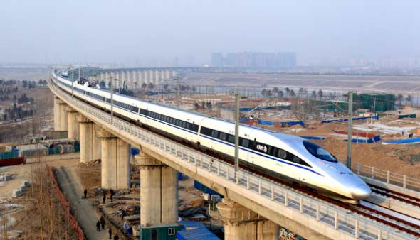 A high-speed train travelling to Guangzhou is seen running on Yongdinghe Bridge in Beijing, Dec 26, 2012. [File photo by Jiao Hongtao/China Daily] 
