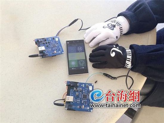 A player shows magical gloves that allow users to create music by moving fingers on a table. (Photo: www.taihainet.com)