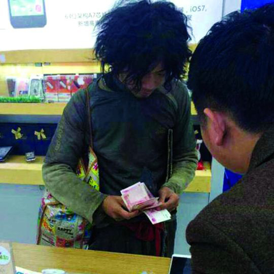 A beggar-like man counts out money to buy an iPhone 6 in Wenzhou, eastern China's Zhejiang province. (Photo: nandu.com)
