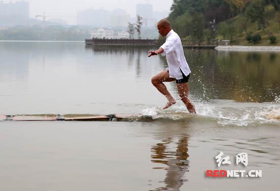 Shi Liliang, a monk from Quanzhou Southern Shaolin Monastery, walks on water in Changsha city, Central China's Hunan province. (Photo: rednet.cn)