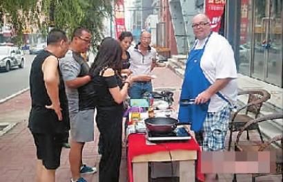 Michael Kraus (R) is seen selling sausages in Changchun city of North Chinas Jilin province. (Photo: New Culture Newspaper)