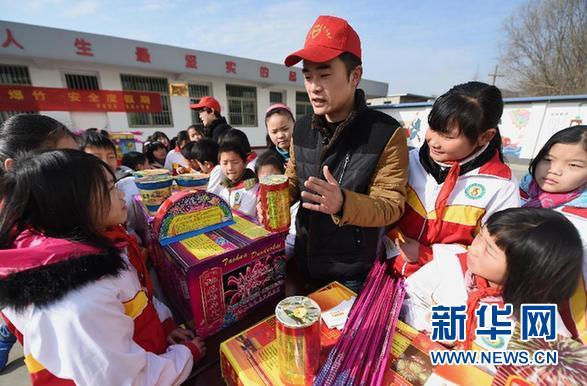 A volunteer explains the risks of playing fireworks. (Xinhua file photo)
