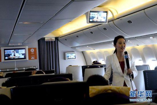 Passengers on flight CA1303 watch a live broadcast of the ongoing “Two Sessions” on China Central Television via Wi-Fi. (Photo/Xinhua)
