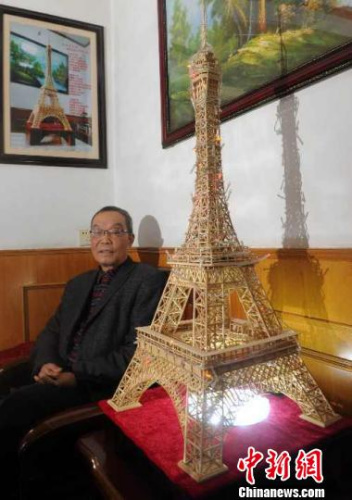 Yao Shunxiang and his Eiffel Tower model made of bamboo sticks. (Photo/Chinanews.com)