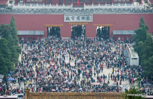 The northern gate of the Palace Museum is crammed with tourists in Beijing, Oct. 2, 2014. Beijing will introduce a tax refund policy this year to boost the spending capacity of international tourists in the capital, Beijing News reports on Tuesday. (Photo/Xinhua) 