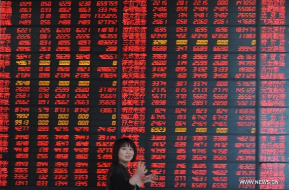 An investor looks through stock information at a trading hall of a securities firm in Fuyang City, east China's Anhui Province, April 21, 2015. (Photo/Xinhua)