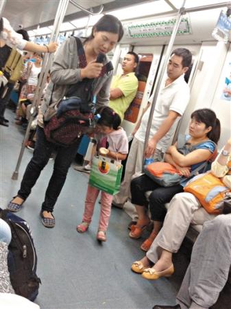 A woman begs on a subway train in Beijing.(File photo/Beijing News)