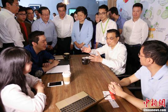 Premier Li Keqiang shares a light moment with entrepreneurs at a 3W Cafe in Zhongguancun Science Park in Beijing on May 7, 2015. (Photo/Chinanews.com)