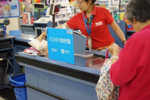 A sign with Alipay is seen in a Wal-Mart store. (Photo/Chinanews.com)