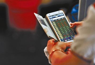 A stock investor checks the market on mobile phone. (Photo/Chinanews.com)