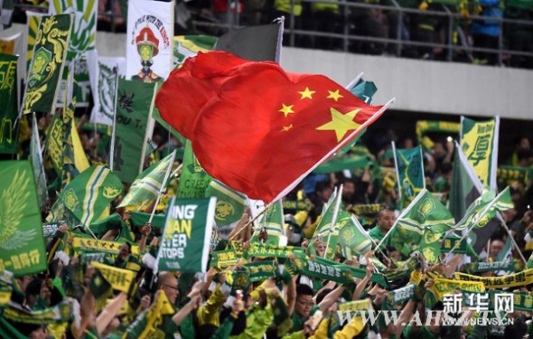 Fans of Guo'an, Beijings local football team, cheer for the team on April 21, 2015. (File photo/Xinhua)