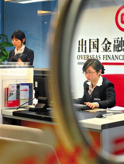 Staff members of a bank offer business service. Chinese commercial banks are competing against each other to seize a share in a market catering for overseas financial needs, as they hope to attract more high-end clients. (Photo/Beijing News)