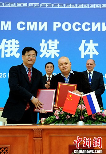 China News Service (CNS) President Zhang Xinxin (L, fornt) and Dmitry Kiselev (R, front), head of the Russia Today international news agency, sign a cooperation deal on the sidelines of the China-Russia Media Forum in St Petersburg on Thursday. (Photo/China News Service)