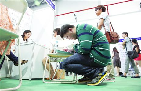 A college graduate fills a form at a job fair. (Photo/Shanghai Morning Post)