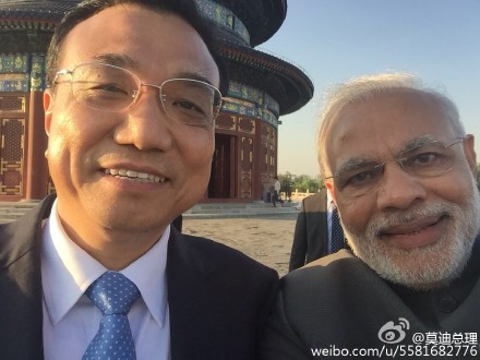 Modi shows a group photo of him and his counterpart Li Keqiang. (Modi's Sina Weibo)