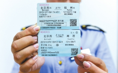 A railway policeman holds a new train ticket (up) and an old one (down). (Photo/Chinanews.com)