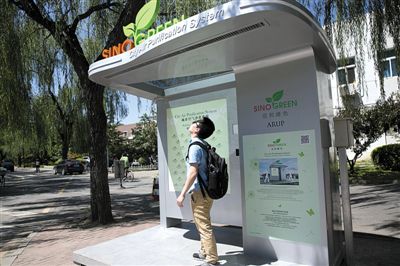 A student breathes clean air at a bus-stop shaped air-purifying device in Tsinghua University. (Photo/Beijing News) 
