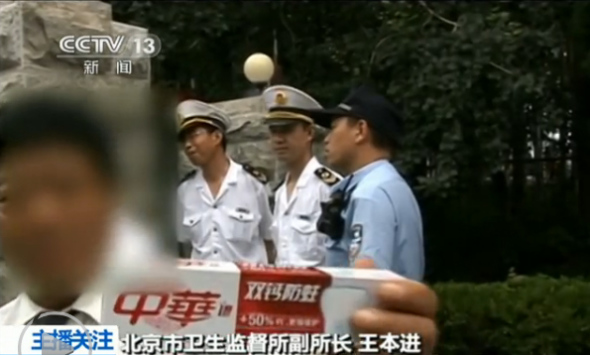 A staff member of a conference center attached to the China National Tobacco Corporation (CNTC), a state-owned manufacturer of tobacco products, shows a box of toothpaste when anti-smoking law enforcers inspect the center. (Photo/Screenshot from CCTV) 