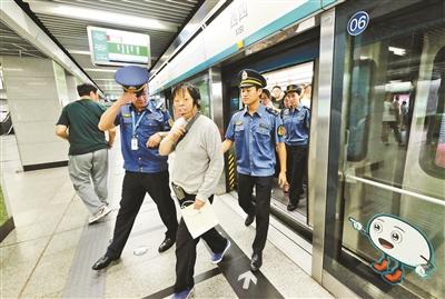 A subway beggar is persuaded to leave the train. (File photo/Beijing Youth Daily)