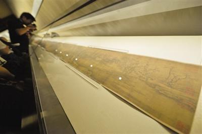 The famous riverside scroll Along the River during the Qingming Festival is unfoled for exhibition at the Palace Museum in Beijing, Aug 28, 2015. (Photo/The Beijing News)