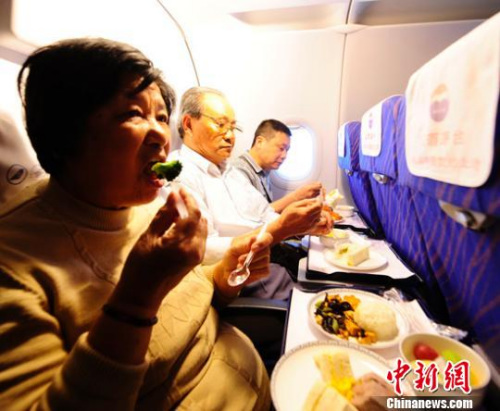 Passenger enjoy hot meals on an airplane. (File photo/chinanews.com)