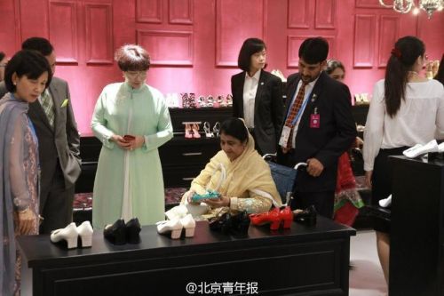 Pakistani President Mamnoon Hussain's wife ((L4) tries shoes at Silk Street market. (Photo/Weibo)
