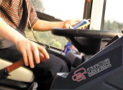 A bus driver watches his smart phone while drving on a highway in Chongqing. (Photo/cqcb.com)