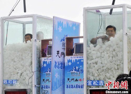 Jin Songhao (R) sits in a box of ice cubes. (Photo/China News Service)