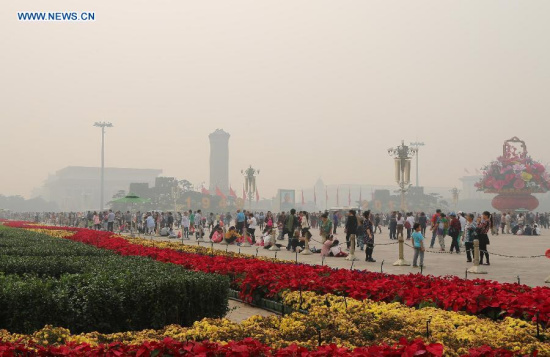 Tourists walk on the Tiananmen Square in haze in Beijing, capital of China, Oct. 7, 2015.(Photo: Xinhua/Liu Xianguo)