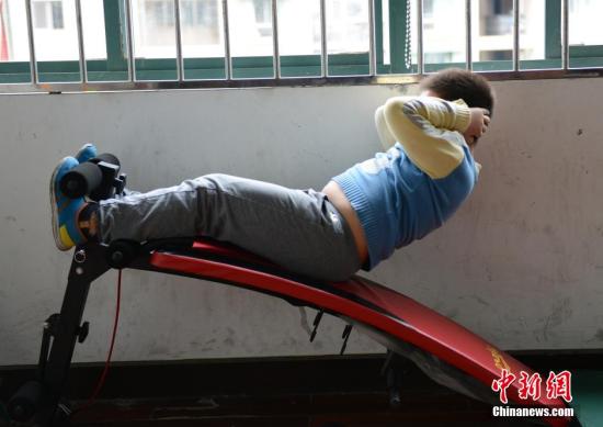 A boy does sit-up exercises. (Photo/China News Service)