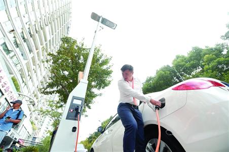 Staff shows the electric car charging function of a lamp pole at Dagu Road, Shanghai on Oct.26, 2015. (Photo/Shanghai Morning Post)