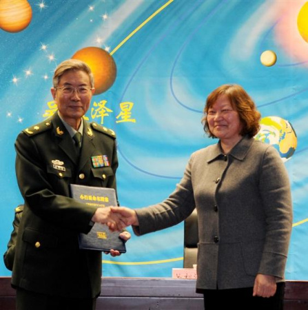 Wu Zuze(L) receives a certificate at the naming ceremony in Beijing on Nov. 30, 2015. 