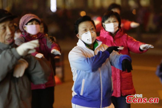 Residents wearing masks dance to rhythms of songs despite smog on a square in Beijing on Monday evening, December 7, 2015. (Photo: China News Service/Li Sihui) 