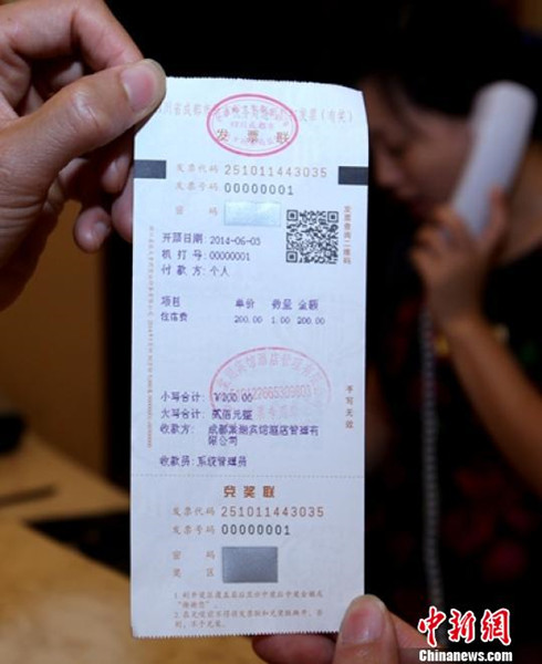 A paper invoice is linked to its electric version with a QR code on the ticket (File photo：China News Service)