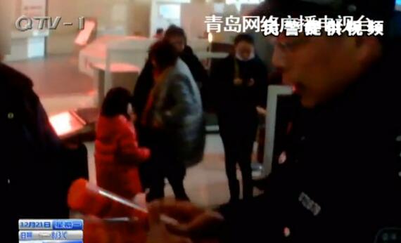 A policeman shows the dangerous signal flares found in a passenger's luggage. (Photo/Qingdao TV)