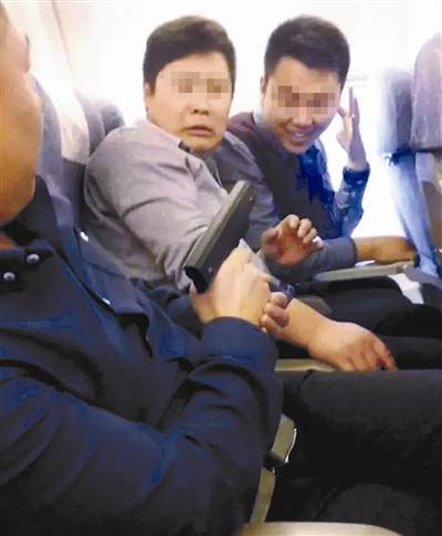 A passenger holds a gun on a plane. (Photo/Beijing Youth Daily)