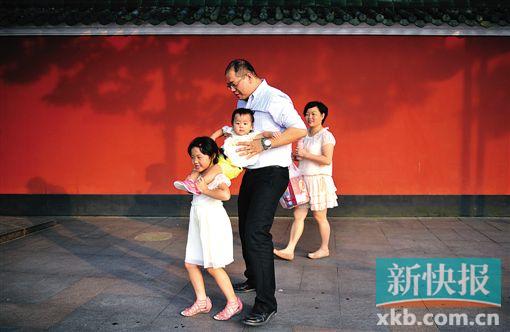 A family of four walk on the street in Foshan, south China's Guangdong Province. (Photo/xkb.com.cn)