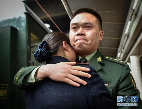 Frontier soldier Pan Ding hugs his wife Lei Yun, a railway attendant at the platform of Guangzhou East Railway Station. (Photo/Xinhua)