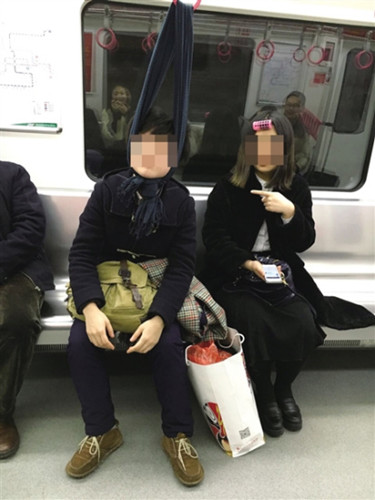 A woman dozes on a subway while letting her head hang in a scarf tied to a handrail. (Photo/cqnews.net)