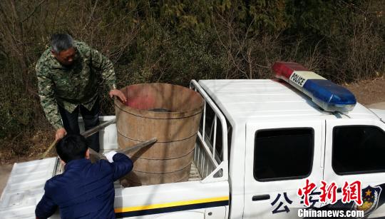 A wooden barrel used by two local wizards to steam a woman to death is seized by police. (Photo/Chinanews.com)