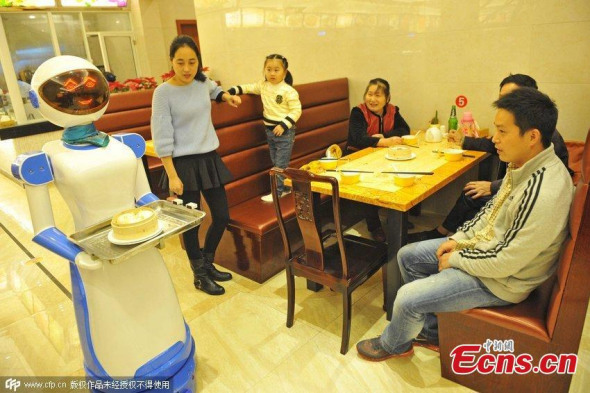 A robot waitress about 1.5 meters works for a Hong Kong style tea restaurant in Haikou, Hainan Province, in August 3,2015.Her Life is about 7 to 10 years, after an electric charge she can keep working 12 hours. She can speak, serve food, sing and greet. (CNS photo/Luo Yunfei)
