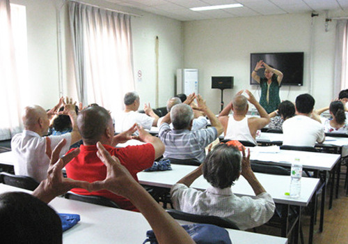 A community volunteer helps to improve the elderly psychological health in a class in Beijing's Haidian District. (File photo) 