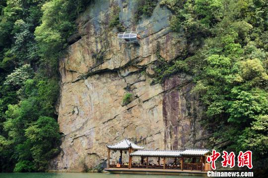 A capsule-like glass room, measuring 3.2 meters long and 1.6 meters wide, hangs from a cliff at Baohu Lake scenic spot in Zhangjiajie City, Central China's Hunan Province. (Photo/Chinanews.com)  