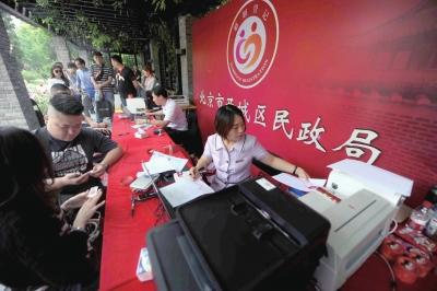 Staff members at a marriage registration office in Beijing offer service for newly-wed couples, May 20, 2016. (Photo/Beijing Times)