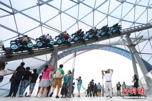 Visitors experience the TRON Lightcycle Power Run ride at Shanghai Disney Resort on its official opening day, June 16, 2016. (Photo/China News Service)