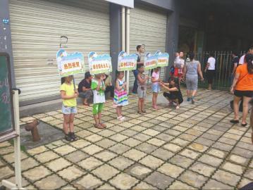 Five kids are seen holding signposts to celebrate daughter of the kindergarten head for achieving high gaokao scores.(Photo/West China Metropolis Daily)