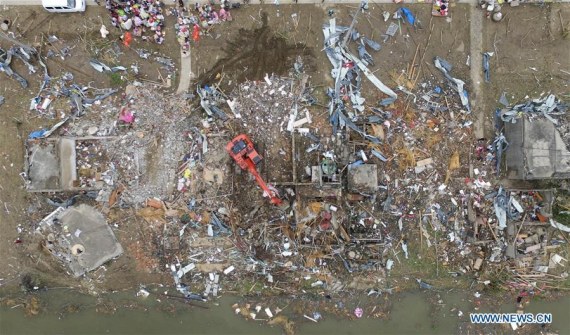 An excavator works in debris in Beichen Village of Funing County, east China's Jiangsu Province, June 24, 2016. (Photo: Xinhua/Ding Ting)